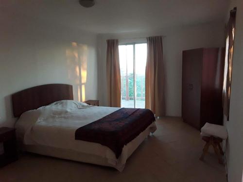 a bedroom with a bed and a large window at Cabaña en Pica con Jacuzzi privado in Pica