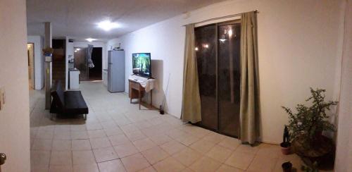 Cabaña en Pica con Jacuzzi privado في بيكا: غرفة مع مدخل مع تلفزيون وأريكة