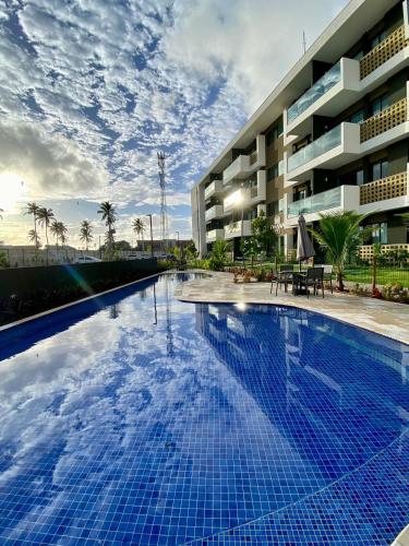a large swimming pool in front of a building at Mana Beach Experience Muro Alto C219 in Porto De Galinhas