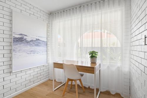 a white room with a desk and a window at The Arches ~ Style, location and spacious living! in McLaren Vale