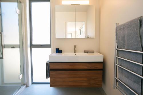 a bathroom with a sink and a mirror at Abodo Alpine Eco Villa (Spa) in Cardrona