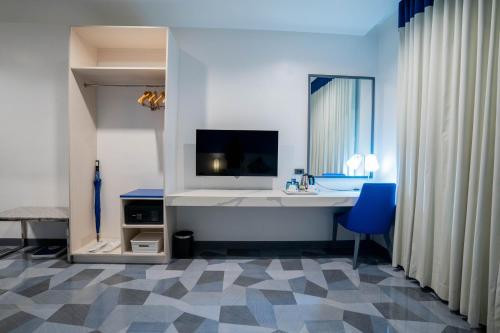 uma casa de banho com uma secretária branca e uma cadeira azul em Stacia Hotel powered by Cocotel em Cebu
