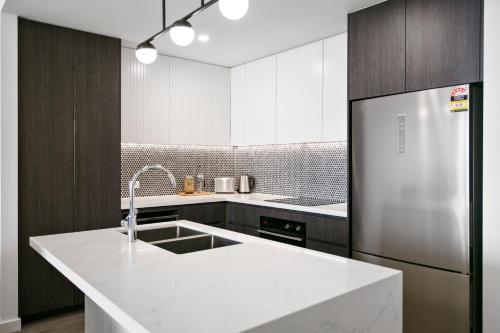 a white kitchen with a sink and a refrigerator at Solaris 412 in Forster