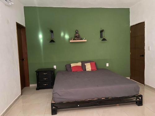 Dormitorio verde con cama y pared verde en FINCA SAN SEBASTIAN en Tizimín
