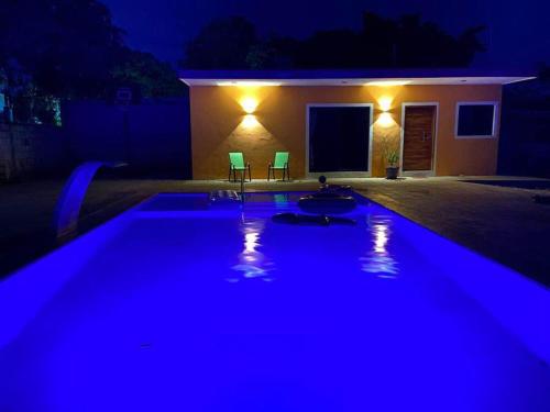 uma piscina iluminada à noite com luzes azuis em FINCA SAN SEBASTIAN em Tizimín