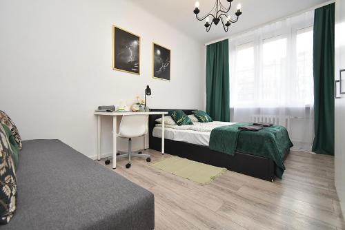 a bedroom with a bed and a desk and a window at Rental Apartments Aleja Niepodległości in Warsaw