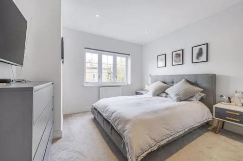a white bedroom with a bed and a window at Elegant 4-Bed Townhouse in Northampton - Free Parking in Northampton