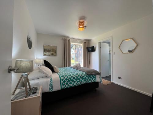 a bedroom with a bed and a window at Boomers Retreat, Alonnah, Bruny Island in Alonnah