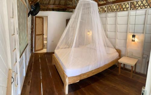 a bed with a mosquito net in a room at Cabañas La Múcura in San Onofre