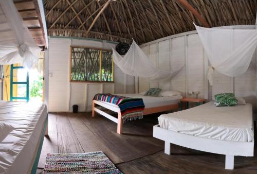 Zimmer mit 2 Betten und einer Hängematte. in der Unterkunft Cabañas La Múcura in San Onofre
