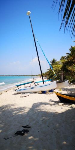 a boat sitting on a beach next to the ocean at Cabañas La Múcura in San Onofre