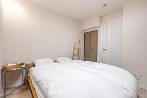 a white bedroom with a large white bed at Hotel STAY ARI Higashishinjuku in Tokyo