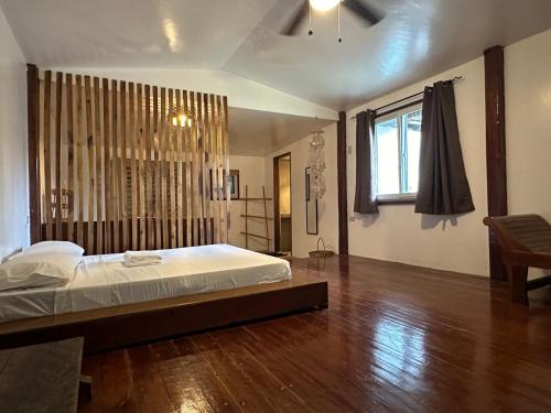 a bedroom with a large bed and a wooden floor at Tribal Xperience Guesthouse in San Vicente