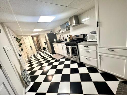 eine Küche mit schwarz-weiß kariertem Boden in der Unterkunft 6-A Diamond in Yonkers, NY in Yonkers