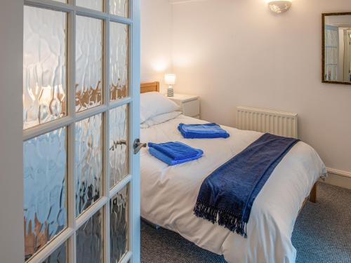 a bedroom with a bed with blue towels on it at The Old Canoe Club in Millbrook