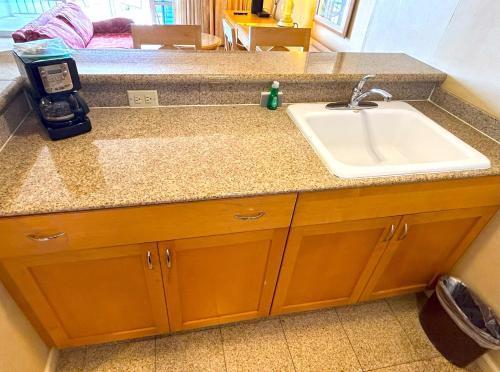 a kitchen counter with a sink and a counter at Ilikai Apt 302 - Spacious Studio with Stunning Ocean & Harbor Views in Honolulu