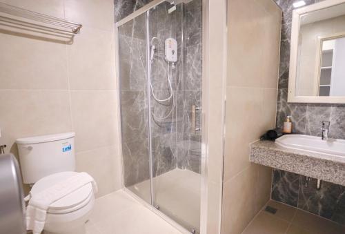 a bathroom with a shower and a toilet and a sink at Bandu Resort in Ban Du