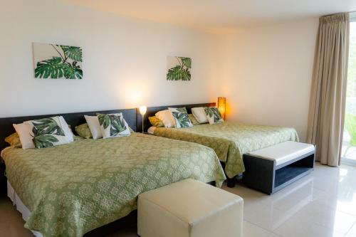 um quarto de hotel com duas camas e uma janela em Amplio y Bello Estudio en Town Center Playa Blanca, Rio Hato em Río Hato