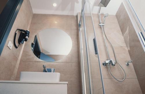 a bathroom with a shower and a sink and a mirror at Hôtel AL AFIFA in Dakar