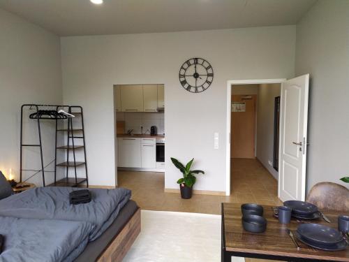 a living room with a couch and a table and a clock at Andris Apartments in Stuttgart