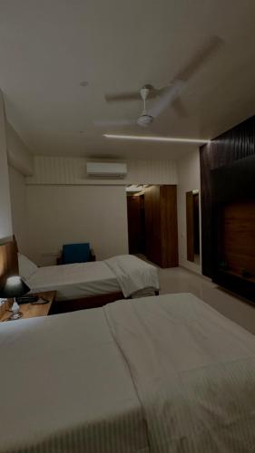 a hotel room with two beds and a fan at DrizzleDrop Inn Chennai in Chennai