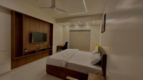 a bedroom with a bed and a flat screen tv at DrizzleDrop Inn Chennai in Chennai
