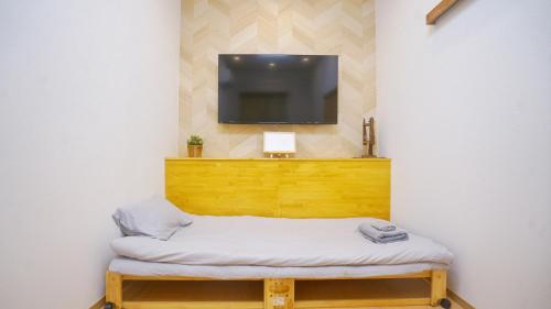 a room with a bed and a tv on a wall at Tokyo Ueno Expert Hotel in Tokyo