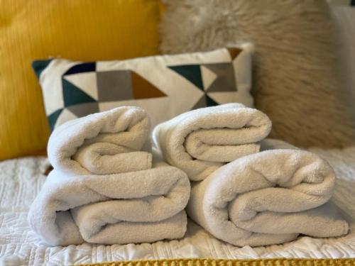 a pile of towels sitting on top of a bed at 4- Lovely 1-bedroom serviced apartment West Midlands 