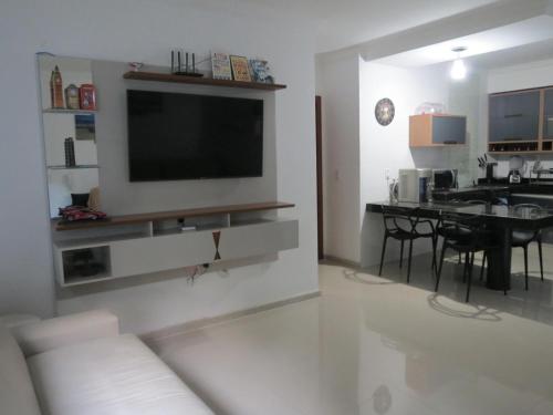 a living room with a flat screen tv on a wall at Recanto do Mundaí - Apto 101 in Porto Seguro