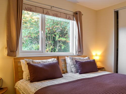 um quarto com uma cama e uma janela em Swallow Lodge em Carsphairn