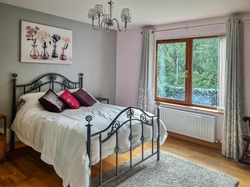 Ceardach في Gelston: غرفة نوم بسرير ومخدات حمراء ونافذة