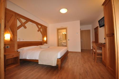 a bedroom with a large bed and a desk at Hotel Select in Andalo