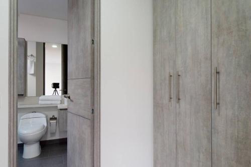 a bathroom with a white toilet and a mirror at Unicentro Delight Norte Bogotá 2 habitaciones in Bogotá