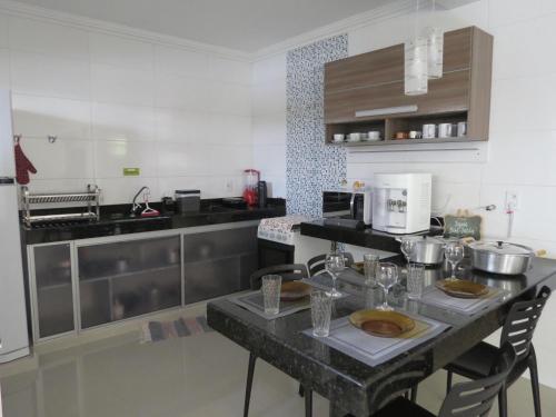 a kitchen with a table with chairs in it at Recanto do Mundaí - Apto 202 in Porto Seguro