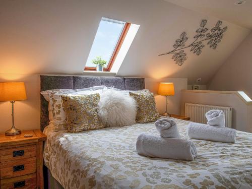 a bedroom with a bed with two towels on it at Little Willow in Saint Columb Major