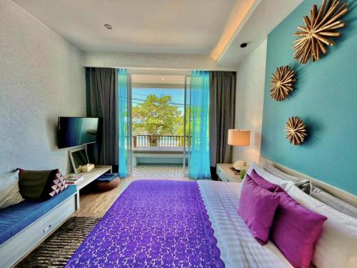 a bedroom with a large purple bed with a purple rug at Mukrada House Boutique Hometel Krabi in Klong Muang Beach