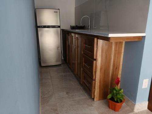 uma cozinha com um frigorífico de aço inoxidável e piso em azulejo em Villa el paraíso em San José