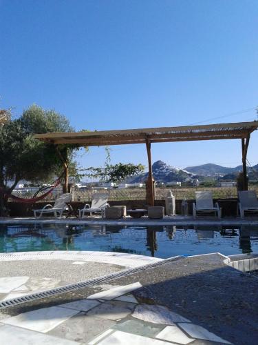 a swimming pool with a gazebo and chairs at Patriko in Skiros