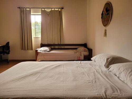 een slaapkamer met 2 bedden en een raam bij EcoviLab in Guaratinguetá
