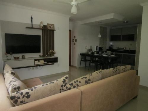 ein Wohnzimmer mit einem Sofa und einem TV in der Unterkunft Recanto do Mundaí - Apto 201 in Porto Seguro