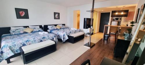 a hotel room with two beds and a television at Hermoso estudio con vista al mar en el Town Center de Playa Blanca Panamá in Río Hato