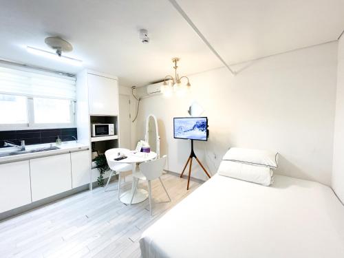 a white bedroom with a bed and a desk at Koin Guesthouse Incheon airport in Incheon