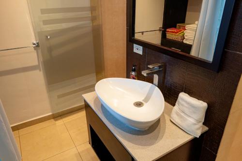 a bathroom with a white sink and a shower at Hermoso estudio con vista al mar en el Town Center de Playa Blanca Panamá in Río Hato