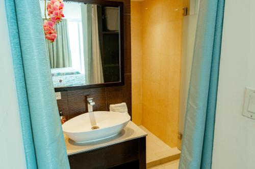 a bathroom with a white sink and a mirror at Hermoso estudio con vista al mar en el Town Center de Playa Blanca Panamá in Playa Blanca