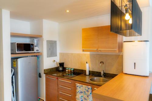 a kitchen with a refrigerator and a sink at Hermoso estudio con vista al mar en el Town Center de Playa Blanca Panamá in Río Hato