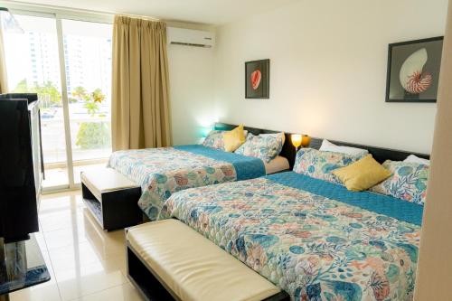 a bedroom with two beds and a window at Hermoso estudio con vista al mar en el Town Center de Playa Blanca Panamá in Río Hato
