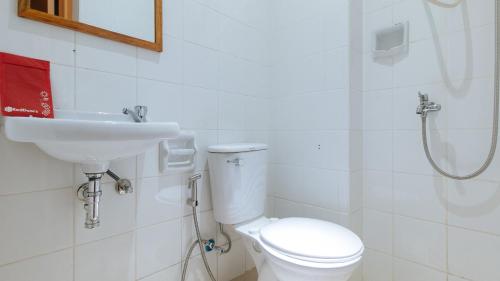 La salle de bains est pourvue d'un lavabo, de toilettes et d'une douche. dans l'établissement RedDoorz @ PVC Pension Haus, à Tagum