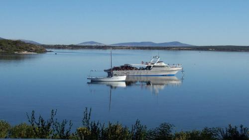 a boat floating on a large body of water at Rest A Shore Coffin Bay in Coffin Bay