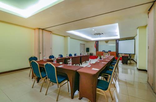 una gran sala de conferencias con una mesa larga y sillas en Hotel Marlin Pekalongan, en Pekalongan