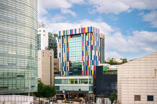a tall building with a colorful facade in a city at Imperial Palace Boutique Hotel Itaewon - Renovated in 2025 in Seoul